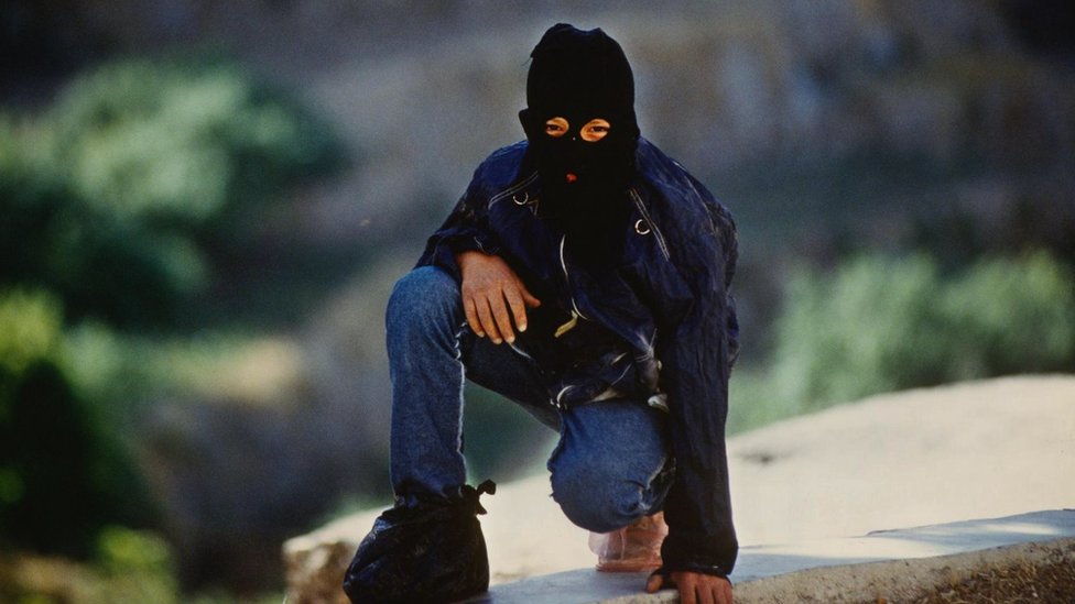 Palestinski borac sa maskom da bi sakrio svoj identitet, na slici patrolira selom na okupiranoj Zapadnoj obali u junu 1989. godine/Getty Images