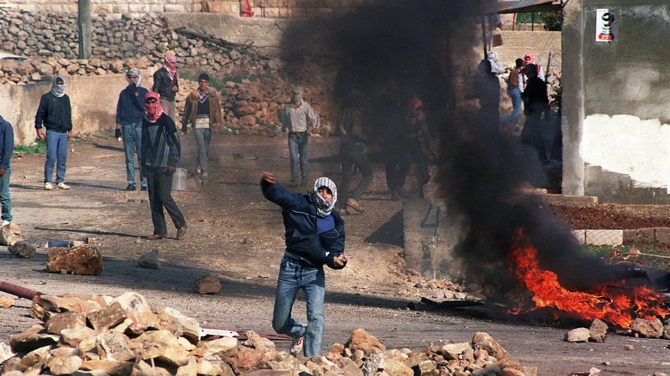 Palestinski demonstranti bacaju kamenje na izraelsku policiju za razbijanje demonstracija u selu Hizme u Severnom Jerusalimu, 21. decembra 1987, proglaenim &Danom mira& u znak podrke Palestincima na Okupiranim teritorijama/Getty Images