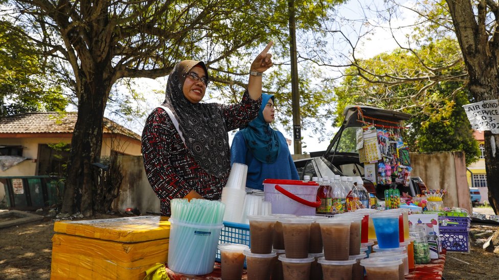 Maturantkinja Siti Ain (desno) sa majkom, koja prodaje pie i hranu ispred kole/Joshua Paul for the BBC