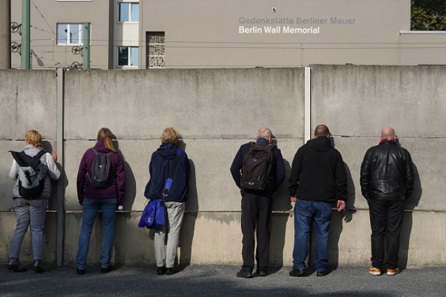 Turisti vire kroz rupe u ostacima zida. Foto: GettyImages/Sean Gallup