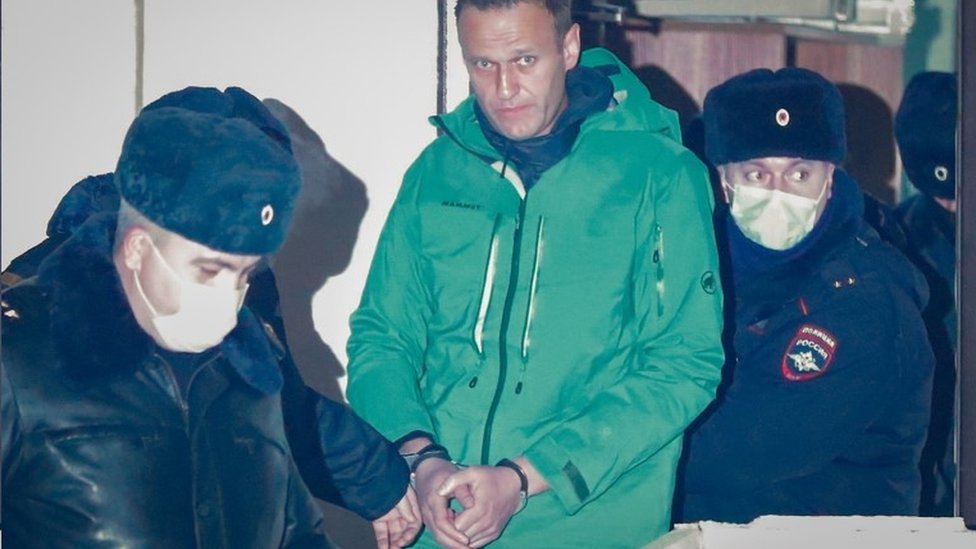 Navaljni sa lisicama na rukama okruen policajcima/EPA