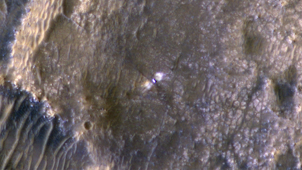 Na ovoj fotografiji moe se videti rover Istrajnost u krateru Jezero, est dana posle sletanja. Sa bonih strana rovera mogu se videti i dve svetle zone, nastale prilikom sletanja./Nasa/JPL-Caltech/UArizona