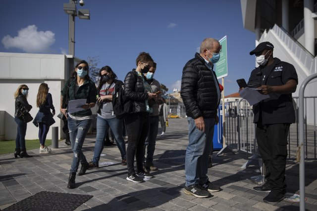 Red ispred stadiona u Izraelu, i osoba koja kontrolie &zeleni paso&. Foto: TANJUG/AP Photo/Oded Balilty