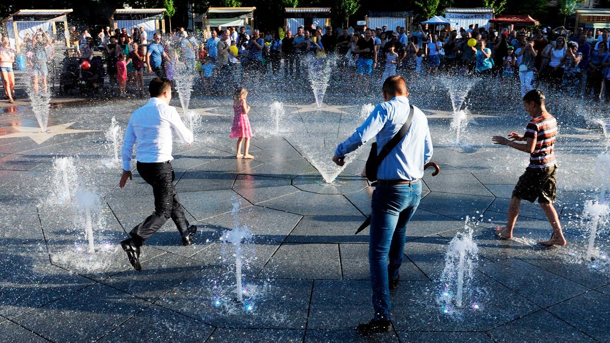 Predsednik Vladimir Zelenski (levo) i deca igraju se u fontani tokom prve zvanine posete Marijupolju 15. juna 2019. godine/Getty Images