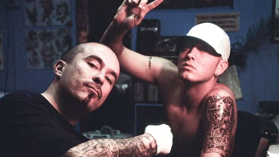 Hip-hop umetnici, poput Eminema (na slici ga tetovira Mister Kartun) uticali su na to da tetovaa postane masovno popularna/Getty Images