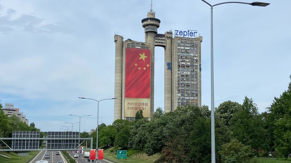 Sa obe strane Geneks kule visi kineska zastava sa porukom dobrodolice/BBC